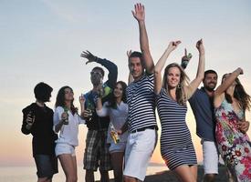 grupo de jovens aproveita a festa de verão na praia foto