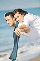 feliz casal jovem se diverte na bela praia foto