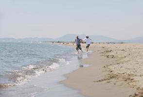 feliz casal jovem se divertir na praia foto