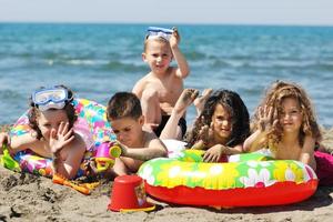 grupo infantil se diverte e brinca com brinquedos de praia foto