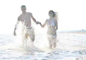 feliz casal jovem tem tempo romântico na praia foto