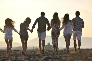 grupo de jovens felizes se divertem na praia foto