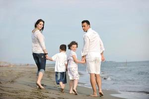 feliz jovem família se divertir na praia foto