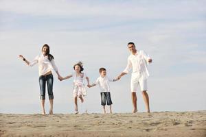 feliz jovem família se divertir na praia foto