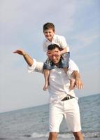 feliz pai e filho se divertem e aproveitam o tempo na praia foto