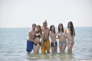 grupo de pessoas felizes se divertir e correr na praia foto