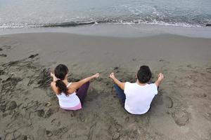 casal ioga praia foto