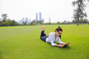 mulher jovem e bonita com tablet no parque foto
