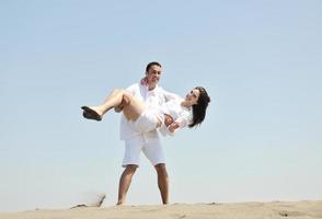 feliz casal jovem se divertir na praia foto