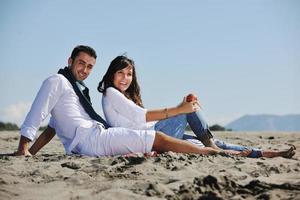 jovem casal desfrutando de piquenique na praia foto