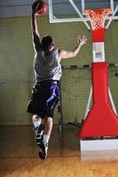 jogador de jogo de bola de basquete no pavilhão desportivo foto