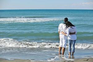 feliz casal jovem se diverte na bela praia foto