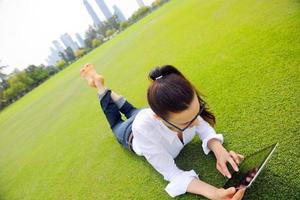 mulher jovem e bonita com tablet no parque foto