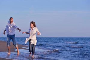 jovem casal na praia se divertir foto