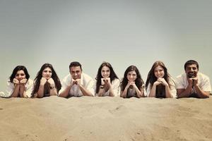 grupo de jovens felizes em se divertir na praia foto