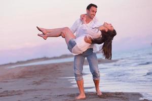 jovem casal na praia se divertir foto