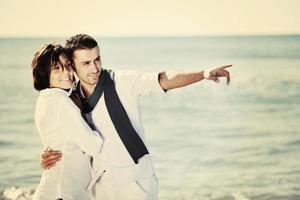 feliz casal jovem se diverte na bela praia foto