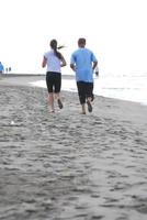 casal correndo na praia foto