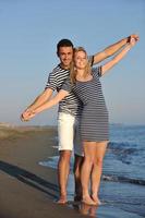 feliz casal jovem tem tempo romântico na praia foto