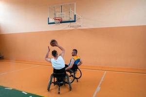 veteranos de guerra com deficiência em ação enquanto jogavam basquete em uma quadra de basquete com equipamentos esportivos profissionais para deficientes foto