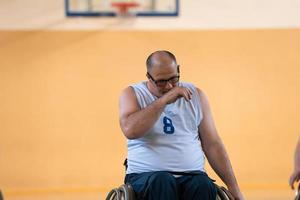 uma foto de um veterano de guerra jogando basquete com um time em uma arena esportiva moderna. o conceito de esporte para pessoas com deficiência