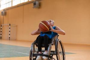 uma jovem jogando basquete em cadeira de rodas em um time profissional. igualdade de gênero, o conceito de esportes com deficiência. foto