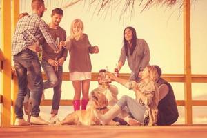 grupo de amigos se divertindo no dia de outono na praia foto