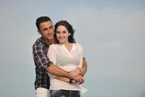 feliz casal jovem se divertir na praia foto