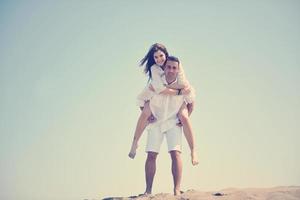 feliz casal jovem se divertir na praia foto