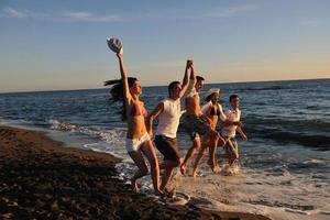 grupo de pessoas correndo na praia foto