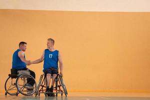 uma equipe de veteranos de guerra em cadeiras de rodas jogando basquete, comemorando pontos ganhos em um jogo. conceito de cinco altos foto