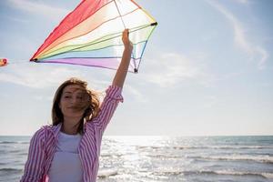 jovem mulher com pipa na praia em dia de outono foto