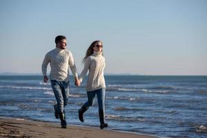 amando o jovem casal em uma praia em dia ensolarado de outono foto