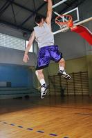 jogador de jogo de bola de basquete no pavilhão desportivo foto