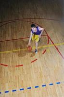 jogador de jogo de bola de basquete no pavilhão desportivo foto