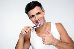 homem feliz escovando os dentes foto
