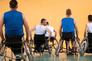 veteranos de guerra com deficiência em ação enquanto jogavam basquete em uma quadra de basquete com equipamentos esportivos profissionais para deficientes foto