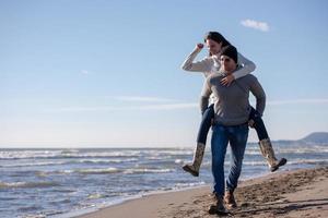 casal se divertindo na praia durante o outono foto