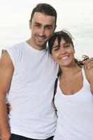 feliz casal jovem se diverte na bela praia foto