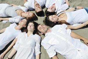 grupo de jovens felizes em se divertir na praia foto