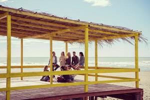 grupo de amigos se divertindo no dia de outono na praia foto