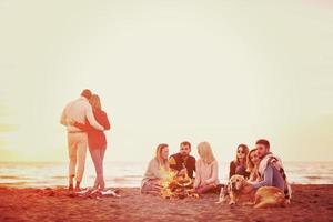 casal curtindo com amigos ao pôr do sol na praia foto