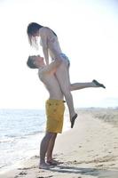 feliz casal jovem tem tempo romântico na praia foto
