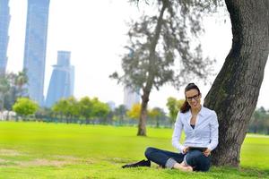 mulher jovem e bonita com tablet no parque foto