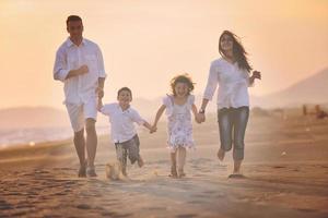 feliz jovem família se divertir na praia foto