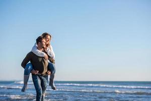 casal se divertindo na praia durante o outono foto