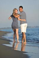 feliz casal jovem tem tempo romântico na praia foto