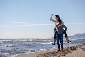 casal se divertindo na praia durante o outono foto