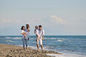 feliz jovem família se divertir na praia foto