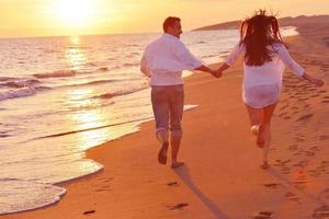 jovem casal na praia se divertir foto